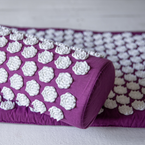 Acupressure mat with white nubs and purple cotton material pillow and mat view