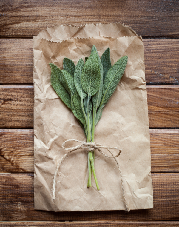 White sage leaves top view on a brown bag wooden table