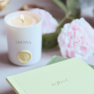 reflect book on a desk with flowers and a lighted candle