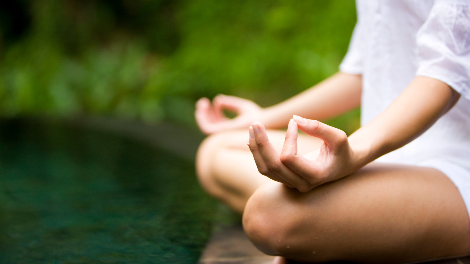 Woman doing yoga and meditation by a lake
